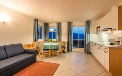 a kitchen and a living room with a couch and a table at Residence Treyer in Terento