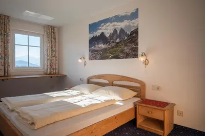 a bed in a bedroom with a picture on the wall at Residence Treyer in Terento