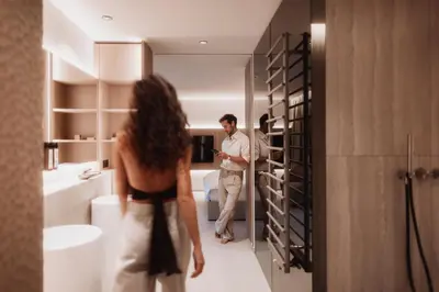 a man and a woman standing in a bathroom at Hotel Solvie in Falzes