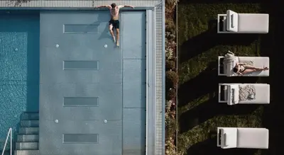 an aerial view of a man standing on the edge of a swimming pool at Hotel Solvie in Falzes