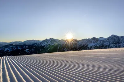 a snow covered mountain with the sun in the background at Hotel Lanerhof active/spa/balance in San Lorenzo di Sebato