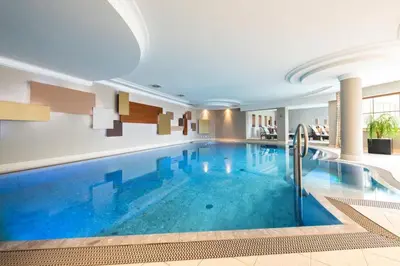 a large swimming pool in a building with a large swimming pool at Hotel Sonnalp in Obereggen