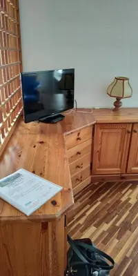 a room with a desk with a television and a table with a lamp at Apartment 18 Federico Bandi Cavalese in Cavalese