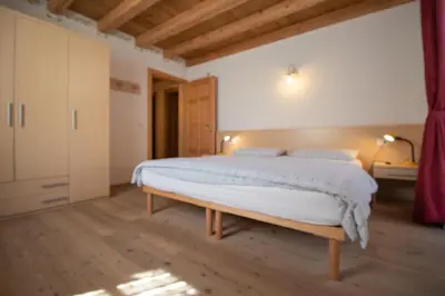 a room with two beds and a chair in it at Casa Torta in Moena