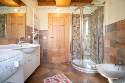 a bathroom with a shower and a sink and a tub at Casa Torta in Moena