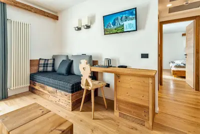 a living room with a couch and a desk at Camina Suite and Spa in Cortina dʼAmpezzo