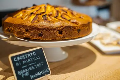 a chocolate cake on a plate on a table with a sign at Camina Suite and Spa in Cortina dʼAmpezzo