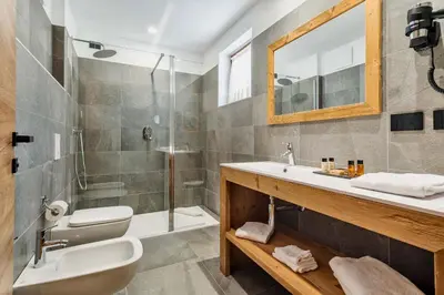 a bathroom with a sink and a shower at Camina Suite and Spa in Cortina dʼAmpezzo
