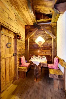 a dining room with a table and chairs in a cabin at Hotel Castel Latemar in Carezza al Lago