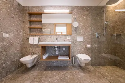 a bathroom with a sink and a toilet and a shower at Hotel Taufers in Molini di Tures
