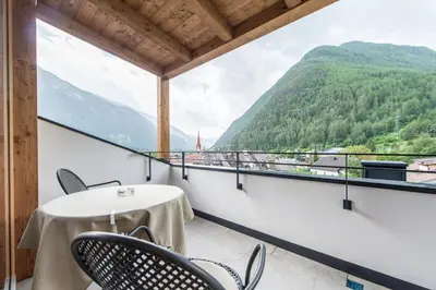 a table and chairs on a balcony with a view at Hotel Taufers in Molini di Tures