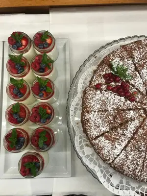 a white table with a cake and some cupcakes at Garni La Vara in Corvara in Badia