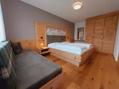 a bedroom with a bed and a bench in it at Residence Stefansdorf in Brunico