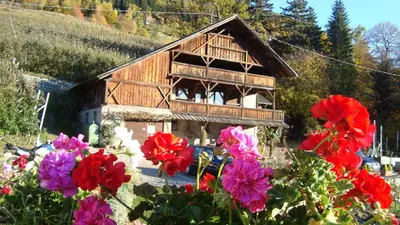 a wooden house with flowers in front of it at Zimmervermietung Gröberhof in Schenna