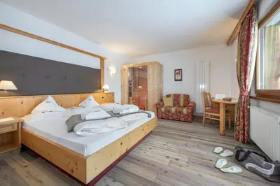 a bedroom with a large bed in a room at Naturhotel Waldheim in Anterivo