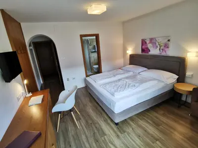 a bedroom with a bed and a table and a chair at Garni Weghueb in Rablà