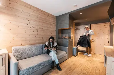 a woman sitting on a couch in a room at Hotel Belvedere in San Martino di Castrozza