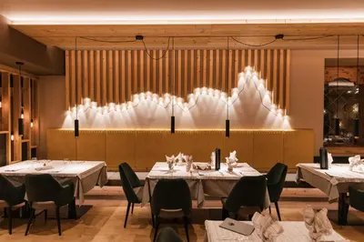 a dining room with tables and chairs and a chandelier at Hotel Belvedere in San Martino di Castrozza
