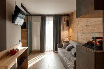 a living room with a couch and a fish tank at Hotel Belvedere in San Martino di Castrozza