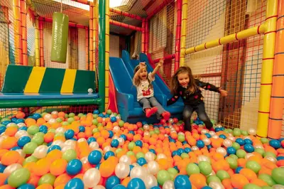 two little girls playing in a large pile of balls at Hotel Belvedere in San Martino di Castrozza