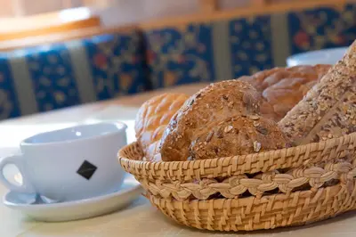 a basket of bread and a cup of coffee on a table at Residence Barbara in Colfosco