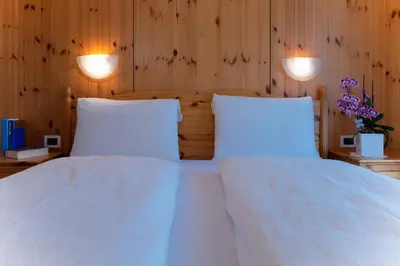 a bedroom with two white beds and two lights at Residence Barbara in Colfosco