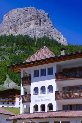 a hotel building with a mountain in the background at Residence Barbara in Colfosco