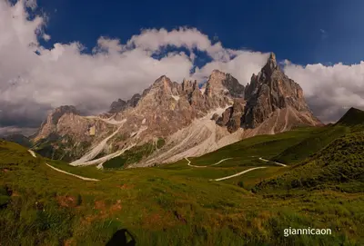 a mountain with a winding road in front of it at Residence Taufer in San Martino di Castrozza