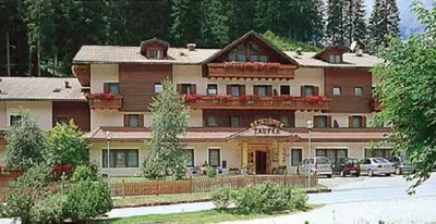 a large building with cars parked in front of it at Residence Taufer in San Martino di Castrozza