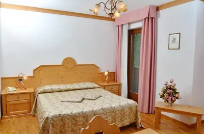 a bedroom with a bed and a window at Residence Taufer in San Martino di Castrozza