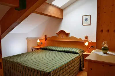 a bedroom with a green bed in a attic at Residence Taufer in San Martino di Castrozza