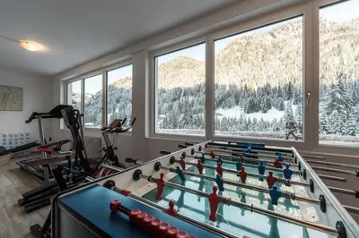 a fitness room with a pool table and a gym at Hotel Sassleng in Canazei