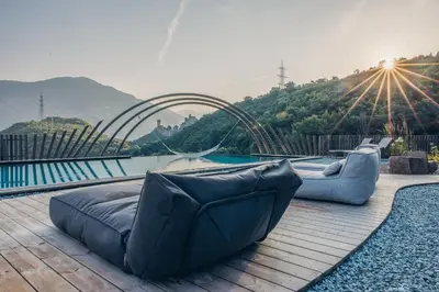 a couch sitting on a deck next to a pool at Hotel Sigmundskron in Appiano sulla Strada del Vino