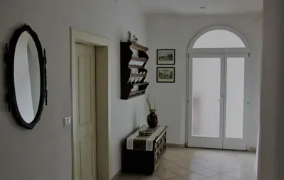 a hallway with a mirror and a table with books at Da Rinota in Alta Val di Non in Malosco