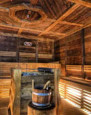 a inside of a wooden cabin with a bucket at Hotel Mirabello - Slow Hotel Benessere in Fiera di Primiero