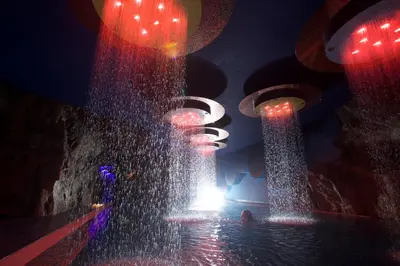 a water fountain in a room with lights at Hotel Mirabello - Slow Hotel Benessere in Fiera di Primiero