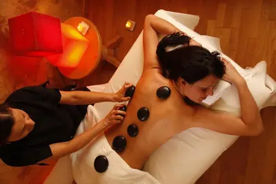 a man and a woman laying in a bed with a body painting a woman at Hotel Mirabello - Slow Hotel Benessere in Fiera di Primiero