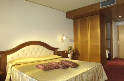 a bedroom with a bed with two pillows on it at Hotel Mirabello - Slow Hotel Benessere in Fiera di Primiero