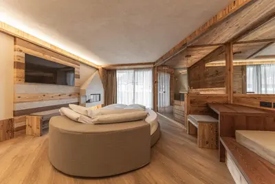a bedroom with a large bed in a room with wooden walls at Hotel Mirabello - Slow Hotel Benessere in Fiera di Primiero