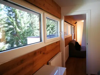 a tiny house with two windows and a couch at Luce Delle Dolomiti con navetta e sala giochi in Mazzin
