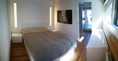 a bedroom with a bed in a white room at Luce Delle Dolomiti con navetta e sala giochi in Mazzin