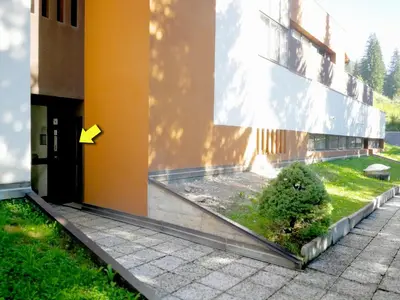 an outside view of a building with an arrow on the side at Luce Delle Dolomiti con navetta e sala giochi in Mazzin