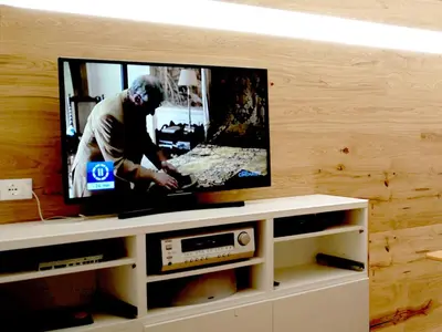 a flat screen tv sitting on top of a tv stand at Luce Delle Dolomiti con navetta e sala giochi in Mazzin