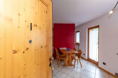 a room with a wooden door and a table at Casa Stella in Falcade