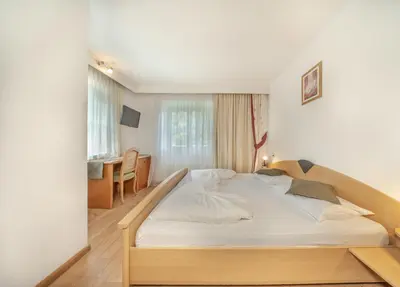 a bedroom with a large bed in a room at Garni Hotel Melissa in Castelrotto