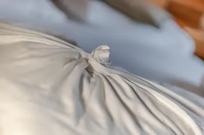 a close up of a white blanket on a bed at Garni Hotel Melissa in Castelrotto
