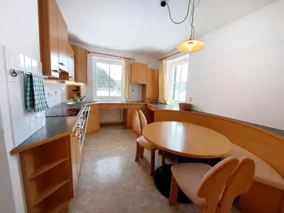 a kitchen with a wooden table and a table and chairs at Garni Hotel Melissa in Castelrotto