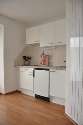 a kitchen with white cabinets and a blender on the counter at Appartements Wiesenheim in Rasun di Sopra