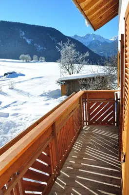 a wooden deck with snow on the ground at Appartements Wiesenheim in Rasun di Sopra