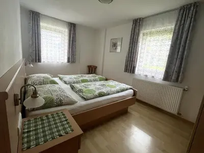 a bedroom with two beds and a table in it at Appartements Wiesenheim in Rasun di Sopra